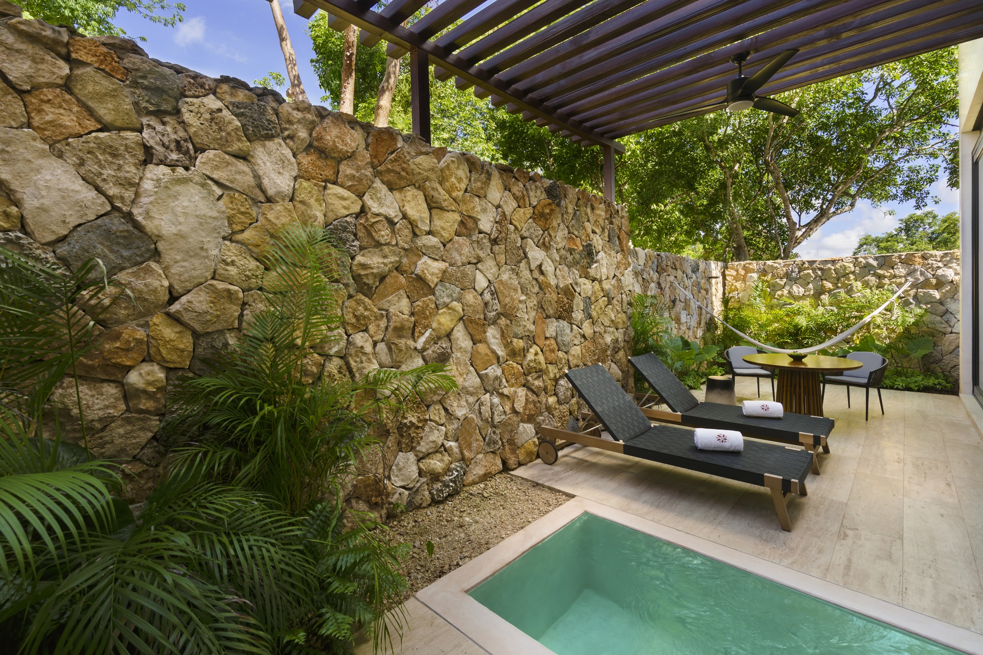 Loungers by a small pool under a pergola at Hacienda Xcanatun, Angsana Heritage Collection.